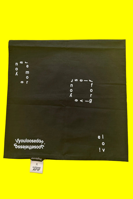 Black bandana scarf with white text on a yellow background