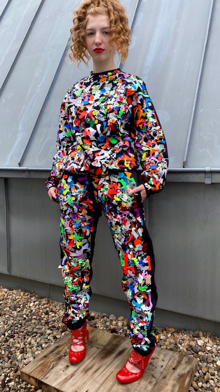 model wearing black tracksuit with multicolor scrap textured on top