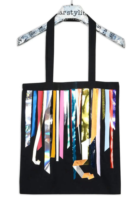 Black tote bag with colorful metallic foil stripes hanging on a printed hanger