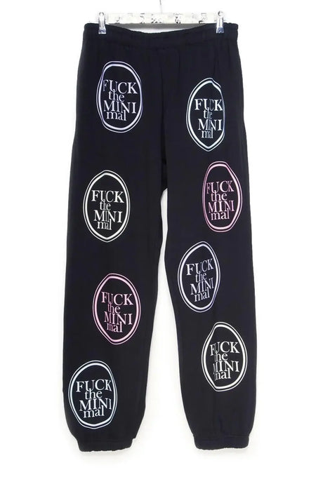 Black jogger pants with bold, colorful graphic oval patches and statement text print.