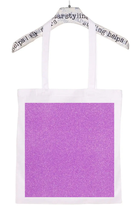 White tote bag with large glittery purple square design, hanging on a printed hanger.
