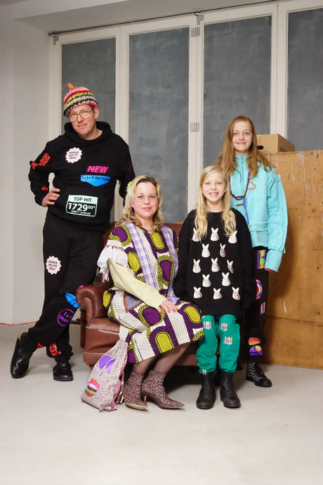 Four people in colorful, patterned streetwear and graphic prints posing indoors.