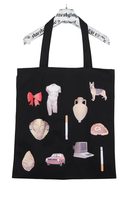 Black tote bag with colorful graphic prints of objects like a bow, statue, dog, and retro items